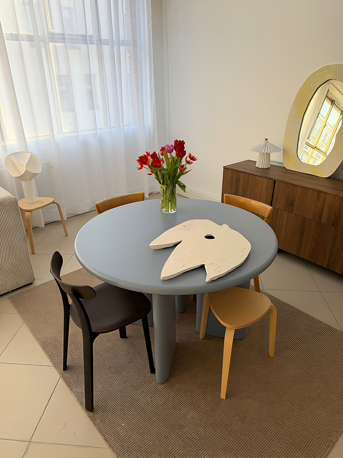 Miroir Oiseau blanc posé sur une table ronde bleue, grand miroir jaune sur un buffet