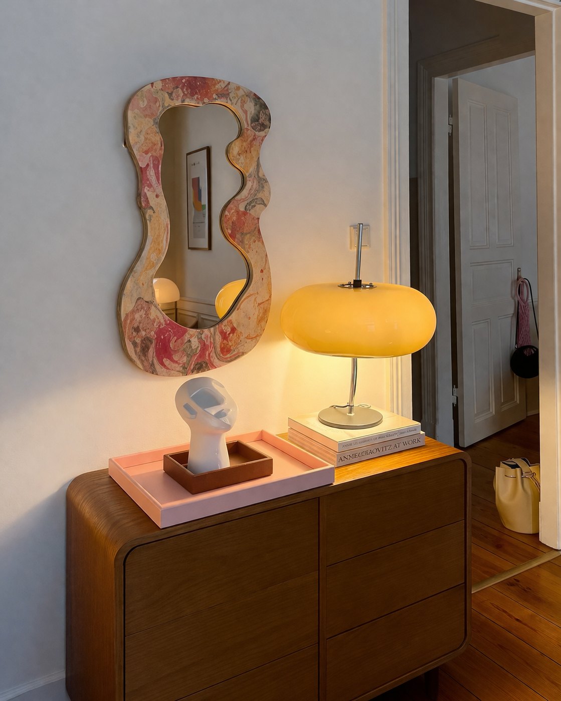Miroir marbré au-dessus d'une commode, lampe allumée