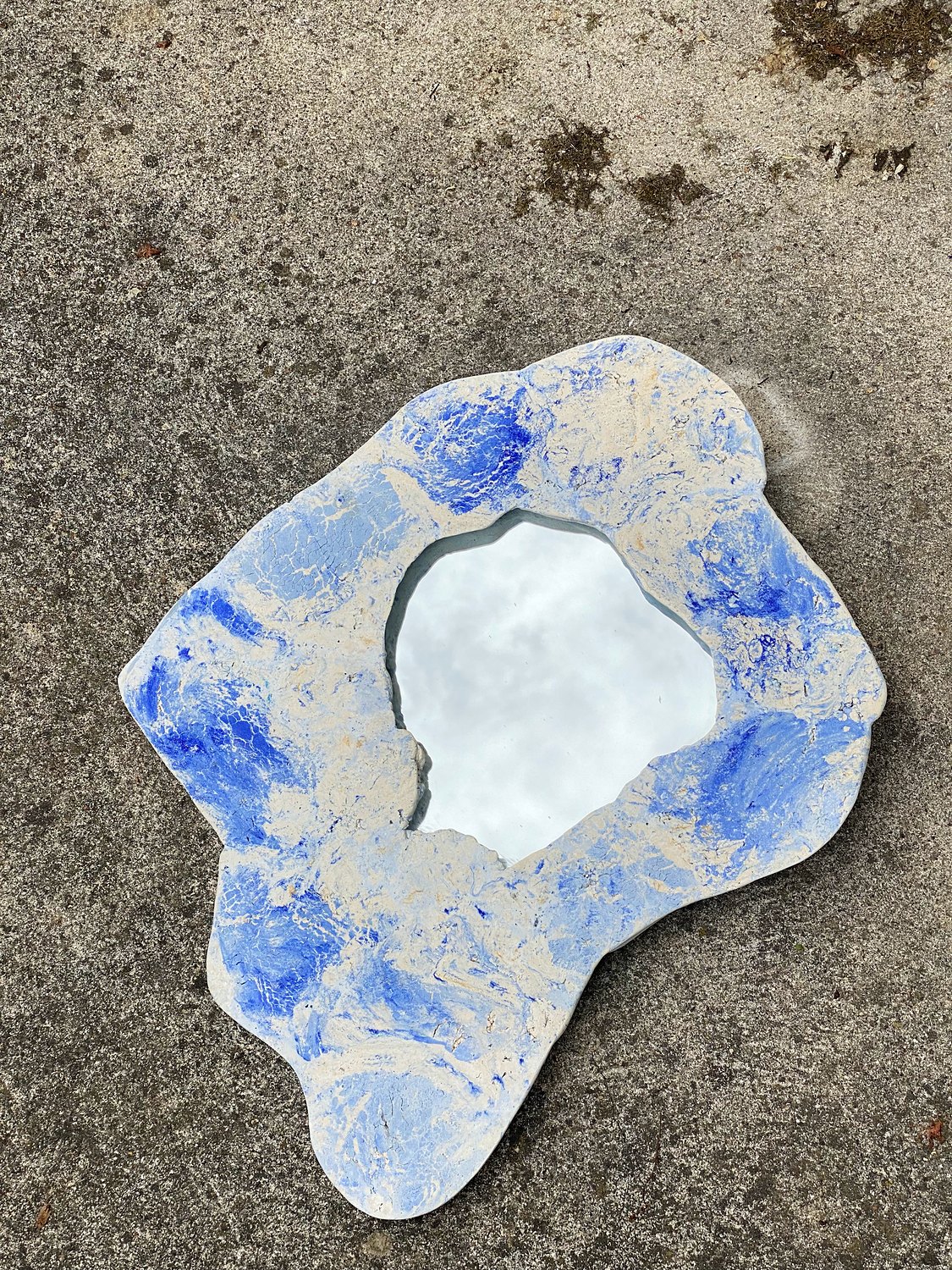 Miroir Îlot bleu et blanc posé sur un sol en béton